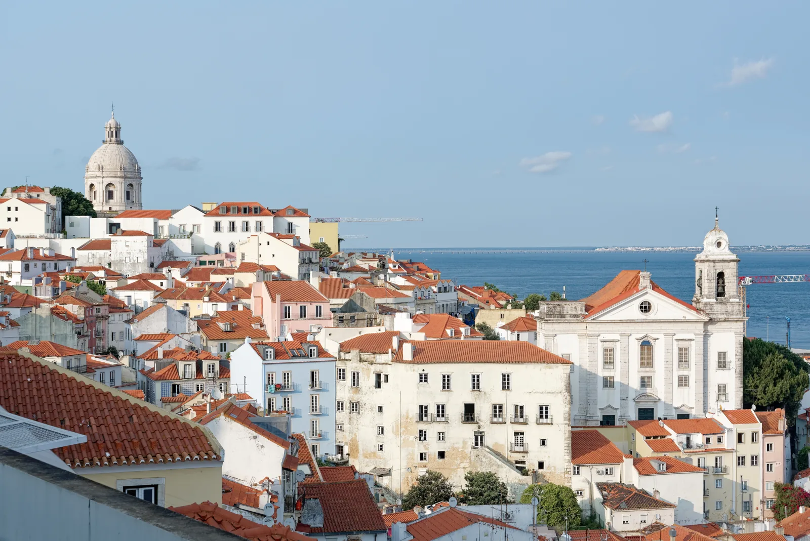 Lisbon rooftops, the Tagus, and tiled terraces seen from Miradouro de Santa Luzia